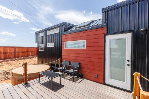 a tiny house with a table and chairs on a deck at Hot Tub & BBQ Deck, Tiny Home Near Zion National Park in Apple Valley