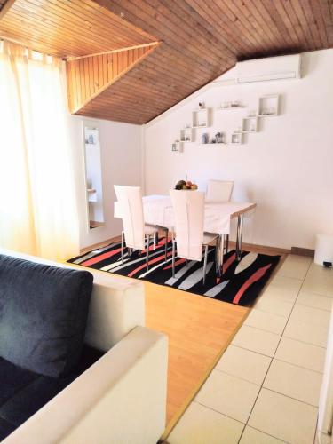 a dining room with a white table and white chairs at Apartments Rose in Zaton