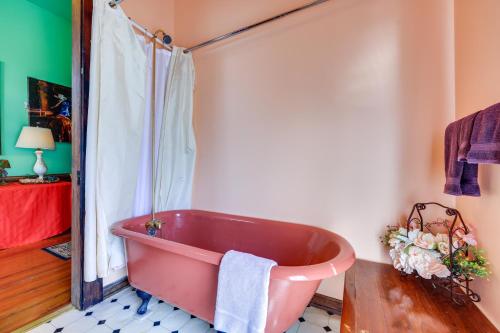a pink bath tub sitting in a bathroom at Grand Gables Home 1 Block to St Johns River! in Palatka
