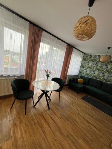 a living room with a table and chairs and a couch at MiniApart w Sercu Suwałk 1 & 2 in Suwałki