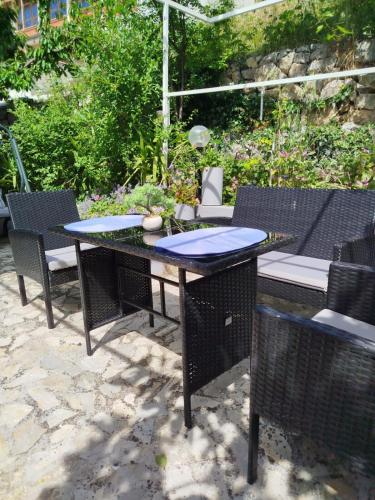 a patio with a table and chairs in a garden at Apartments Rose in Zaton