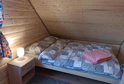 WerlasにあるDomki Bingo i Blueの木製の壁のキャビンのベッド1台