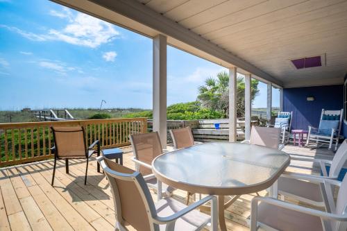 a patio with a table and chairs on a deck at Oceanfront Carolina Beach House - Dogs Allowed -Near Boardwalk in Carolina Beach