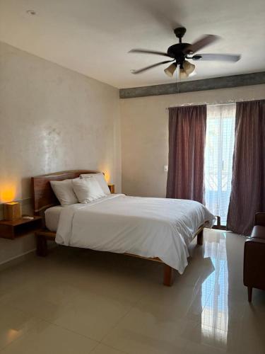 a bedroom with a bed and a ceiling fan at Mexhe Hotel El Cuyo in El Cuyo