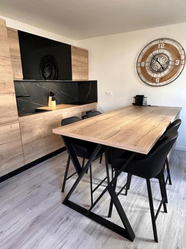 une table à manger avec des chaises et une horloge murale dans l'établissement Maisonnette Gambetta, à Amboise