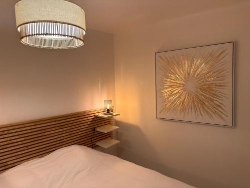 une chambre avec un lit et un tableau au mur dans l'établissement Maisonnette Gambetta, à Amboise