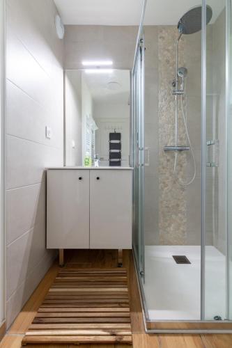 une salle de bain blanche avec une douche et un lavabo dans l'établissement Charmant duplex T4 à Loudenvielle à 50m du skyvall, à Loudenvielle