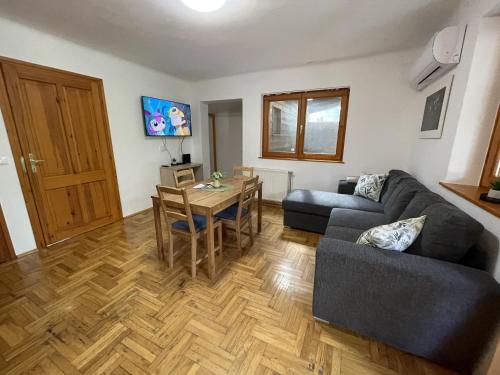 a living room with a couch and a table at Halász Vendégház Jakuzzival Tiszakécske in Tiszakécske