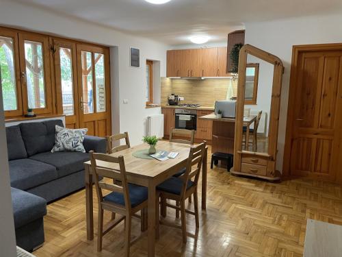 a kitchen and living room with a table and a couch at Halász Vendégház Jakuzzival Tiszakécske in Tiszakécske