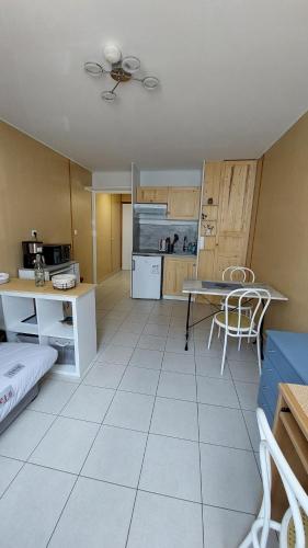 un salon avec une table et une cuisine dans l'établissement Studio Calme, entre centre et plage, à La Rochelle