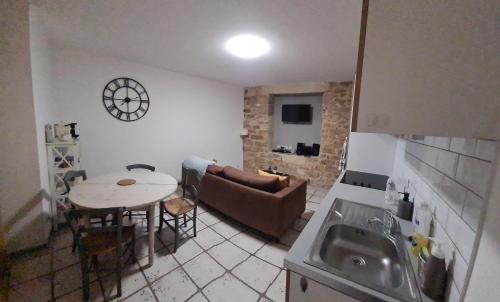 une cuisine et un salon avec une table et un canapé dans l'établissement appartement cosy, à Sarlat-la-Canéda