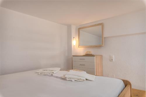 Un dormitorio con una cama con espejo y una cómoda. en Zendaya studios, en Polychrono