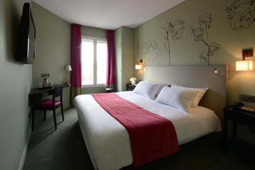 um quarto de hotel com uma cama grande e um cobertor vermelho em Hôtel Orchidée em Paris