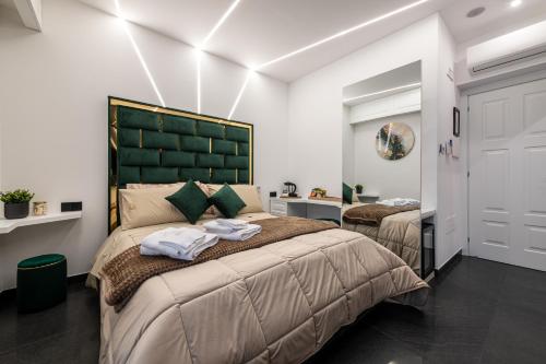 a bedroom with two beds and a large green headboard at La Dimora Cuore & Passione in Naples