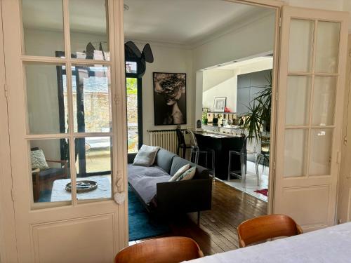 un salon avec un canapé et une table dans l'établissement Maison de caractère Le Mans 3 min à pieds gare et tram, proche centre ville, au Mans