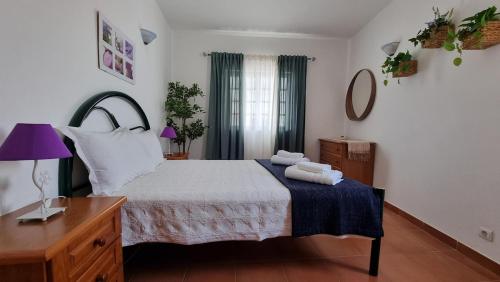 a bedroom with a bed with two towels on it at Burgau Ocean View Apartment in Burgau