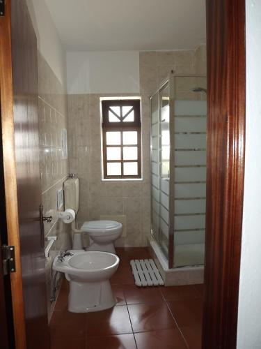 a bathroom with two toilets and a shower and a window at Burgau Ocean View Apartment in Burgau