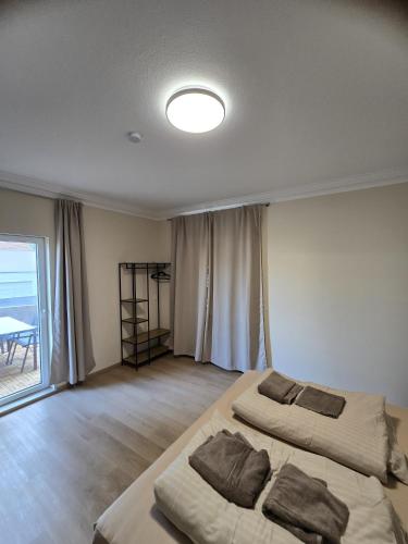 two beds in a large room with a window at Marlin City Apartment in Bielefeld
