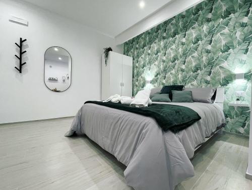 a bedroom with a large bed with a green wall at Casa Vacanza Venere in Barletta