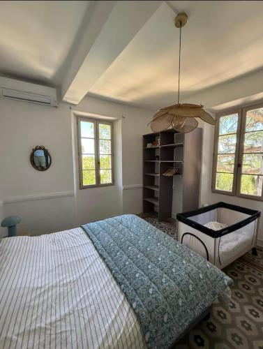 une chambre avec un lit, une table et des fenêtres dans l'établissement La Bastide du Cèdre - 20 minutes from Collioure, à Tresserre