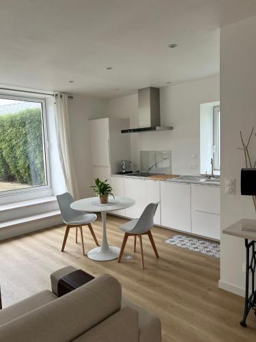 un salon avec une table et des chaises et une cuisine dans l'établissement Petite maison au calme proche bourg, à Le Pener