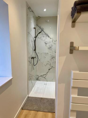 une douche à l'italienne avec un mur en marbre dans l'établissement Petite maison au calme proche bourg, à Le Pener