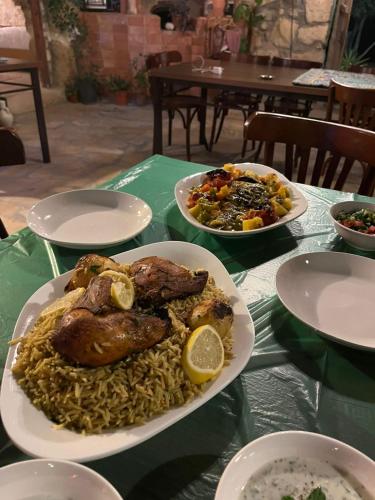 a plate of food on a table with noodles and meat at Hartna zaman in Taiyiba