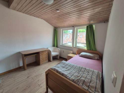 a small room with a bed and a desk and window at Ferienwohnung Goldener Löwe in Heiligenstadt