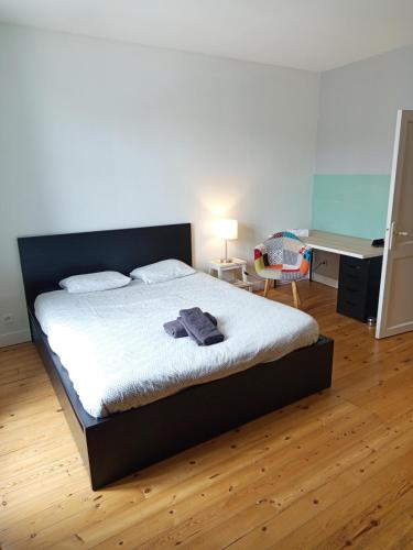 a bedroom with a bed and a desk and a desk at Ancevia, Maison proche gare et Loire avec jardin in Ancenis