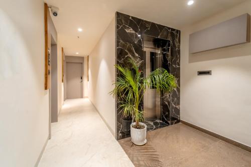 a hallway with a stone wall and two potted plants at Aceotel Select Sarvagya, Vijay Nagar- A Luxury Boutique Hotel -Nipania in Indore