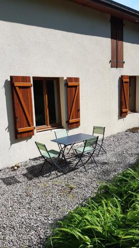 une table et deux chaises devant un bâtiment dans l'établissement Sebea, à Chantraine