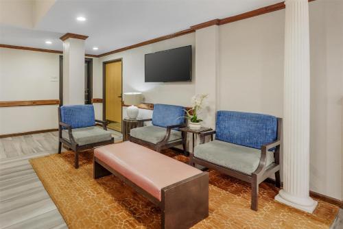 a living room with two chairs and a tv at Best Western Alamo Suites in San Antonio