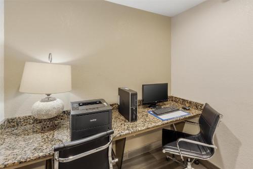 a hotel room with a desk with a computer and a laptop at Best Western Alamo Suites in San Antonio