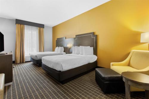 a hotel room with two beds and a chair at Best Western Plus Regency Park in Walker