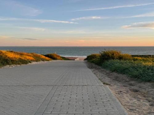 a brick road next to the ocean on a beach at Apartment in Koudekerke near Sandy Beach in Koudekerke
