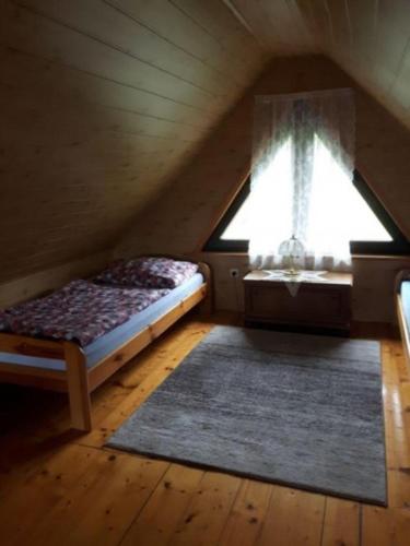 a attic room with a bed and a window at Domki z bali Polanica-Zdrój in Polanica-Zdrój