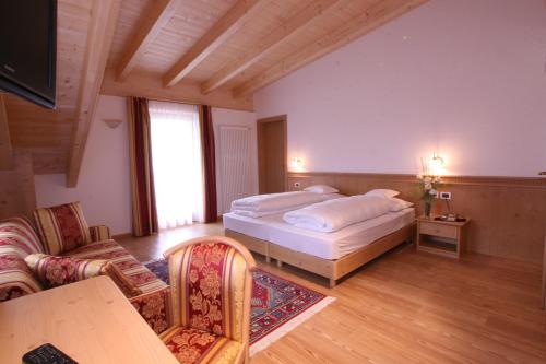 a bedroom with a bed and a table and chairs at Hotel Resa Blancia in San Vigilio Di Marebbe