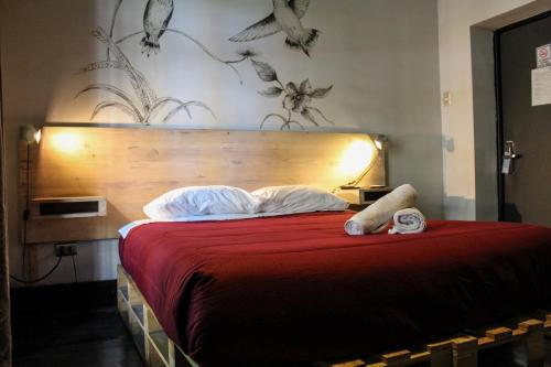 a bedroom with a bed with a red bedspread at Hostel Boutique Merced 88 in Santiago