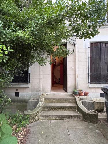 une maison avec des escaliers menant à une porte rouge dans l'établissement Le Henri - Cozy metro 5 min à pied du métro, Paris direct, à Maisons-Alfort