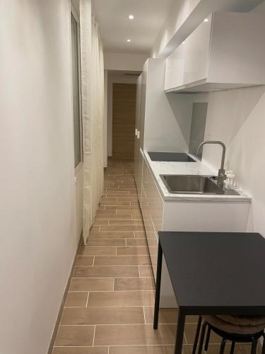 - une cuisine avec un comptoir, un évier et une table dans l'établissement 2 pièces aux porte de Monaco , Plage , Tennis ,GP, à Beausoleil