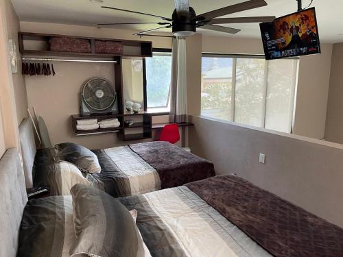 a bedroom with two beds and a ceiling fan at Loft Sole Mio in Orizaba