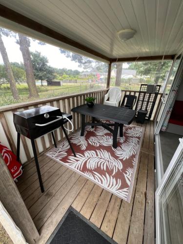 une véranda avec une table et des chaises dans l'établissement La Grande Métairie Location Mobil-Home 4p, à Carnac
