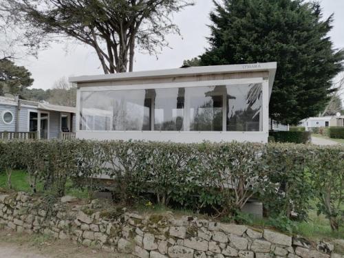 une maison blanche avec un mur en pierre dans l'établissement La Grande Métairie Location Mobil-Home 4p, à Carnac