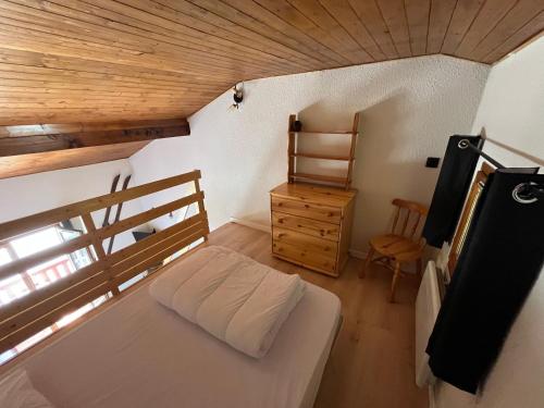 - une petite chambre avec un lit et un plafond en bois dans l'établissement Duplex 4 couchages La Toussuire, à La Toussuire