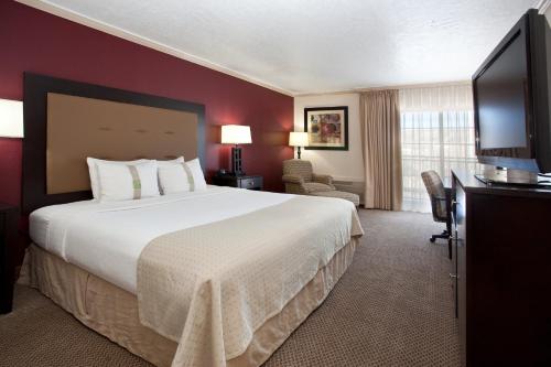 a hotel room with a bed and a flat screen tv at Holiday Inn Rock Springs by IHG in Rock Springs
