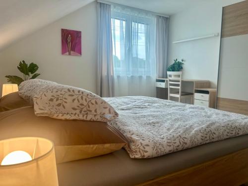 a bedroom with a bed with pillows and a window at Zelený dom v raji in Letanovce