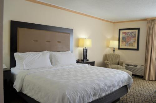 a hotel room with a large bed and a chair at Holiday Inn Rock Springs by IHG in Rock Springs