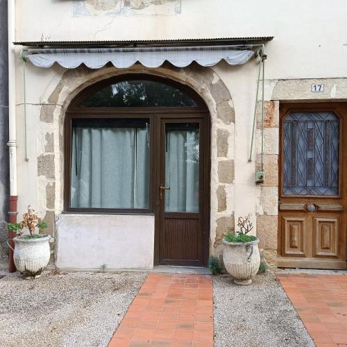 - une entrée pour une maison avec une porte en bois dans l'établissement Chez Ginette, à Castéra-Verduzan