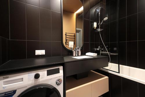a bathroom with a washing machine and a mirror at FORUM apart in Lviv