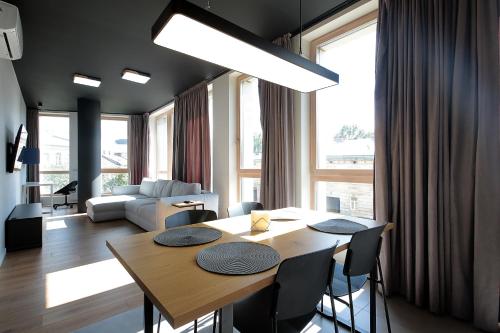 a dining room with a table and chairs and a living room at FORUM apart in Lviv